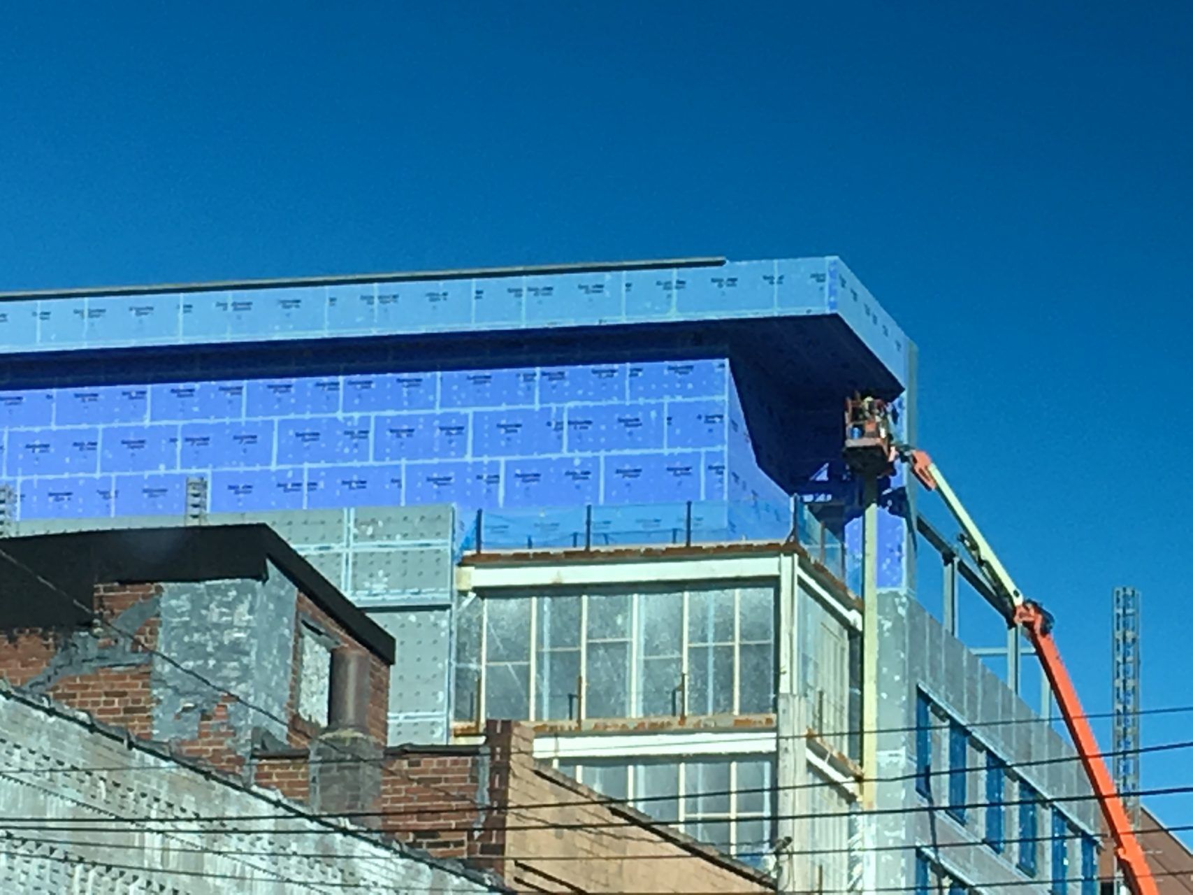A building is being built with a crane beside  it.