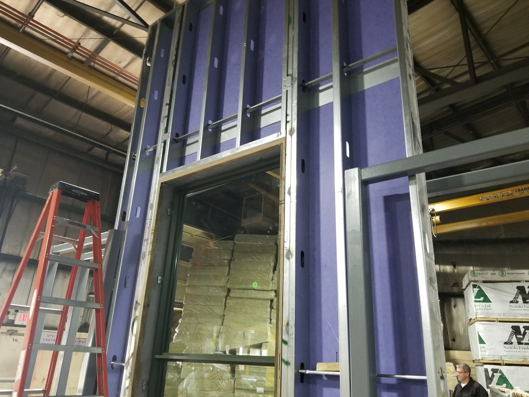 A man is standing in front of a building under construction.