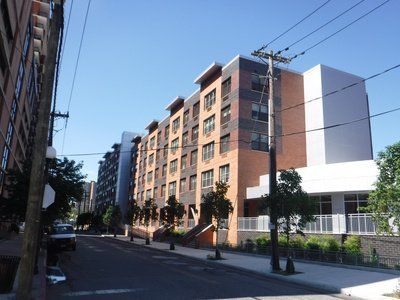 A large building with a lot of windows sits on the corner of a street.