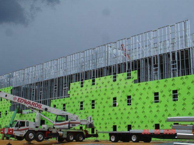 A edwards truck is parked in front of a building under construction.