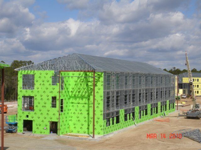 A large building is being built with green insulation.