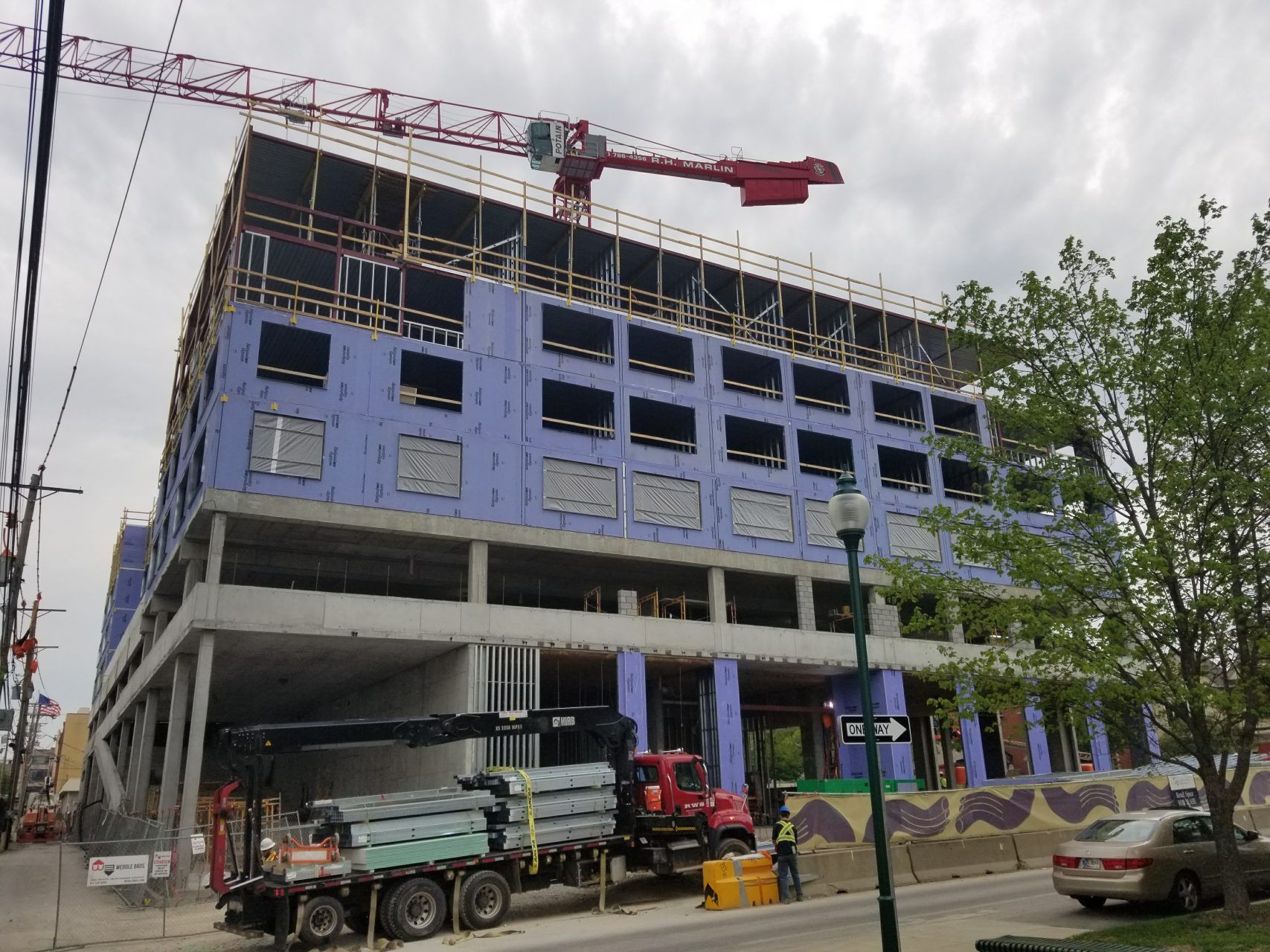 A truck is parked in front of a building under construction.