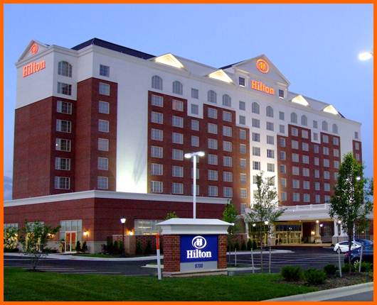 A large Hilton Garden Inn is lit up at night.