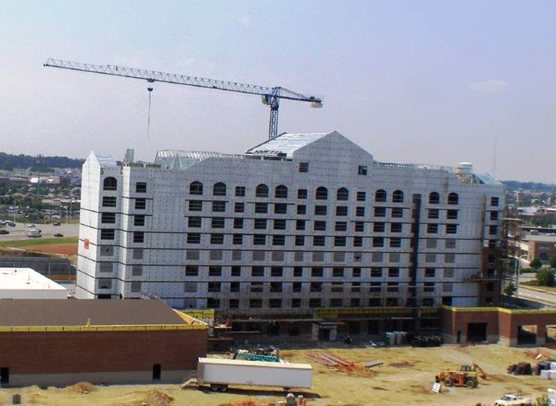 A large white building under construction with a crane in the background.