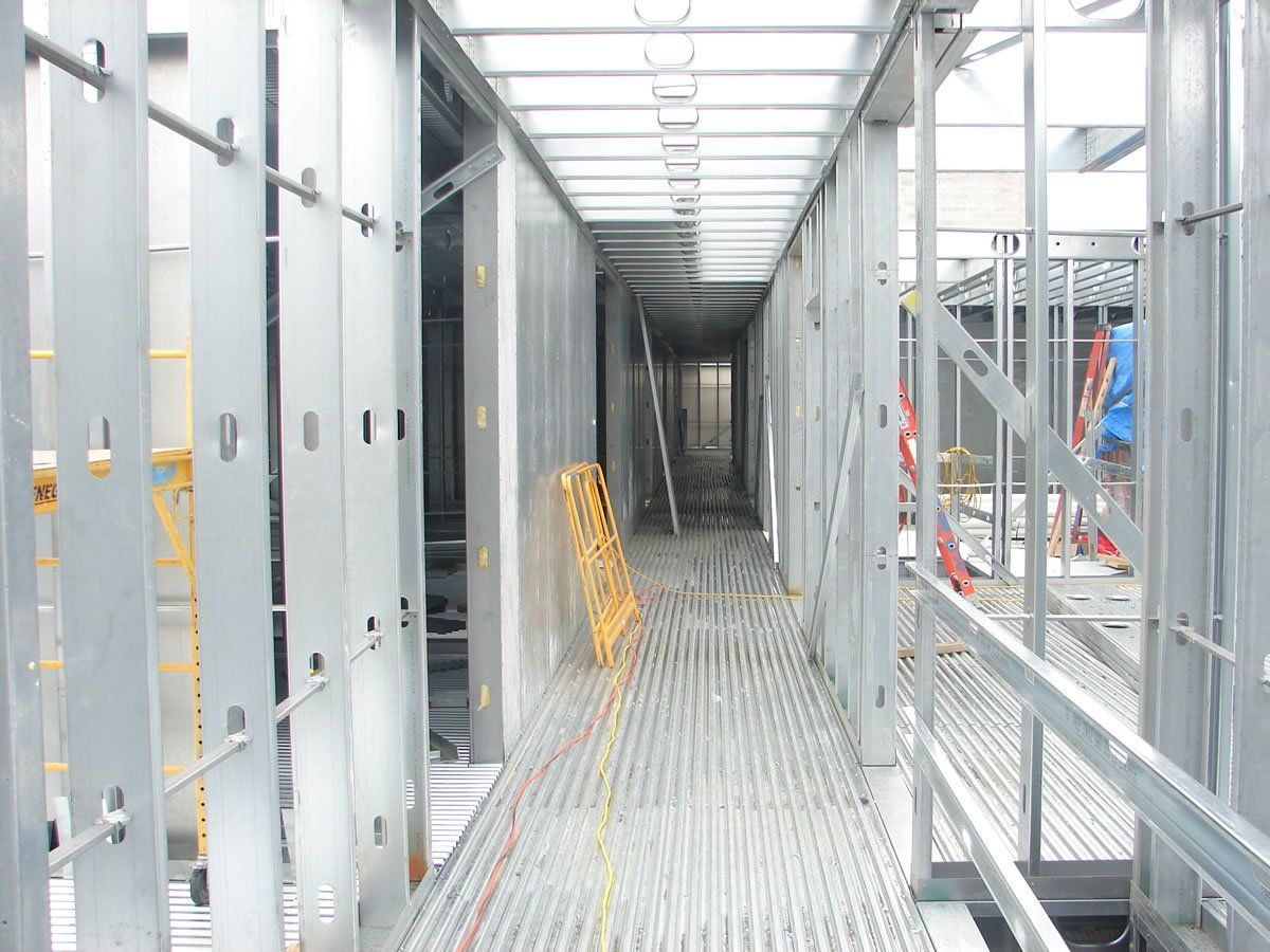 A long metal hallway with a ladder on the side of it.