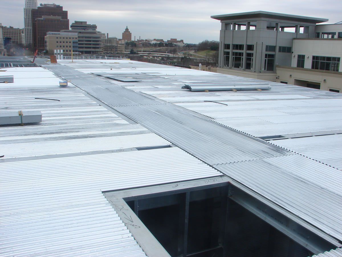 A roof with a hole in it and a city in the background.