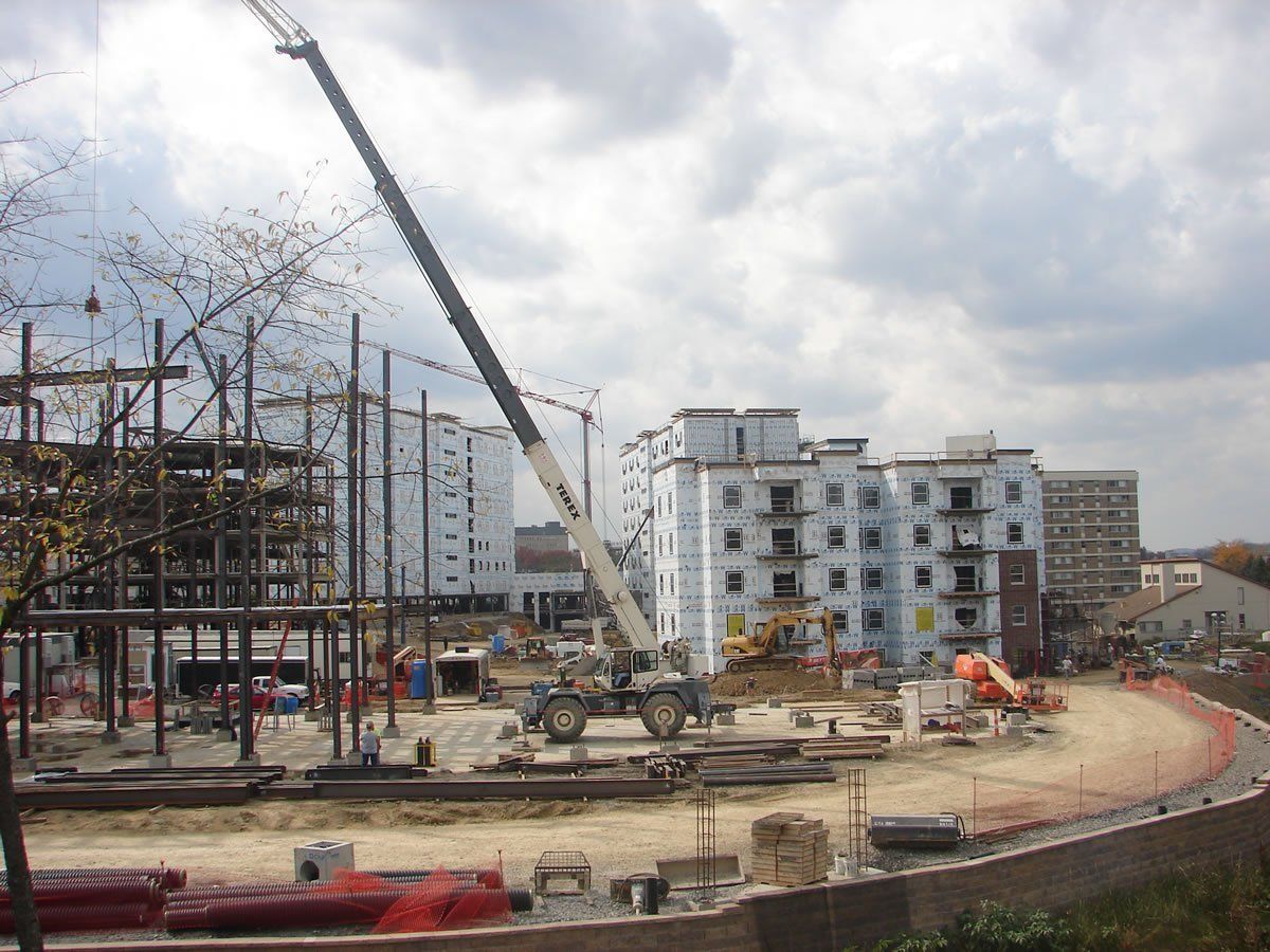 A construction site with a large crane in the foreground.