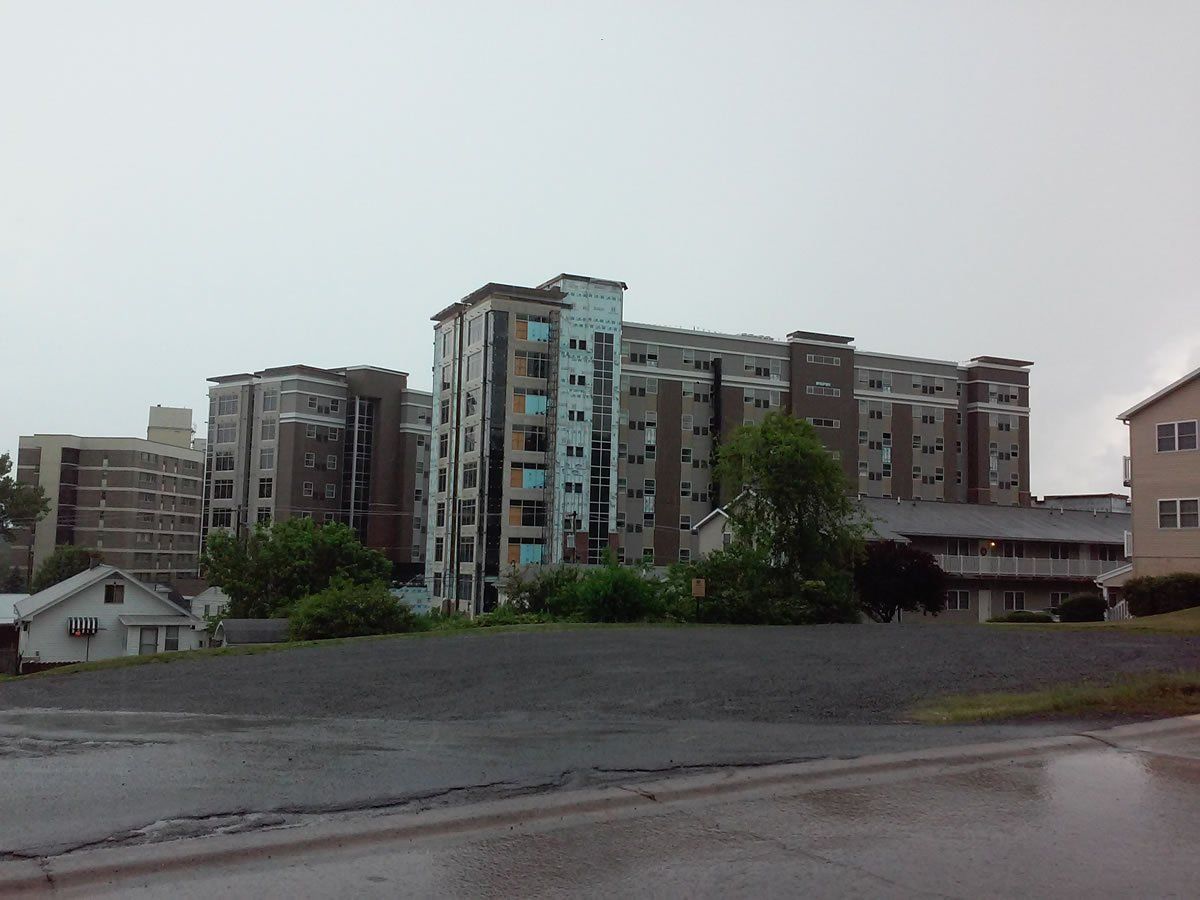 A row of tall buildings with a gray sky in the background.