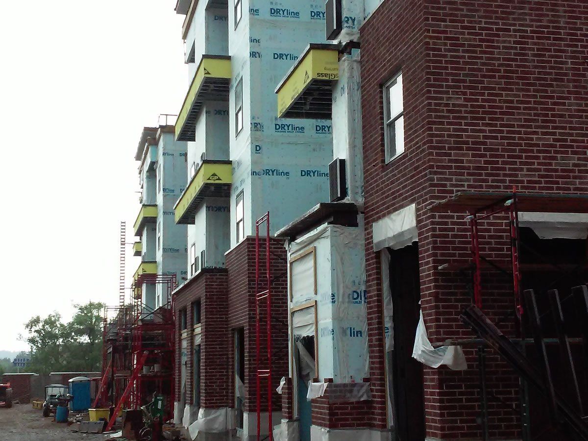 A row of brick buildings are being built.