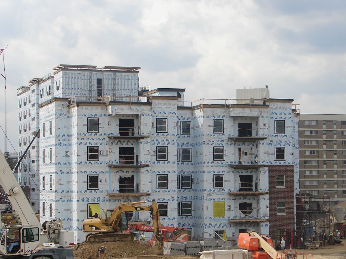 A large building under construction with a crane in front of it.