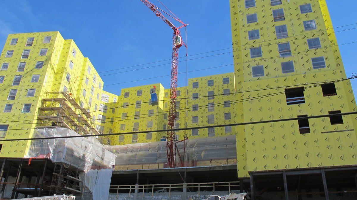 A large building under construction with a crane in the background.