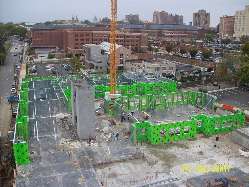 An aerial view of a building under construction with a crane in the background.