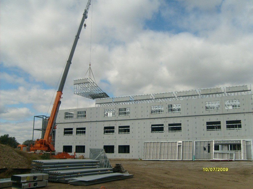 A large building under construction with a crane in the foreground.