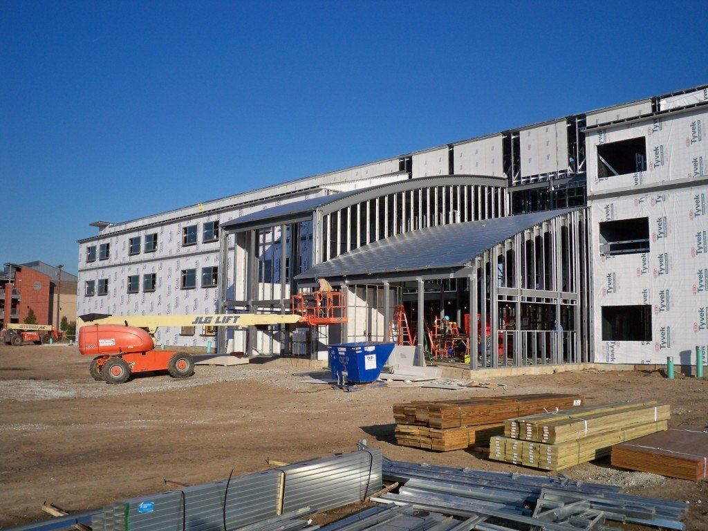 A large building under construction with a jlg lift in the foreground.