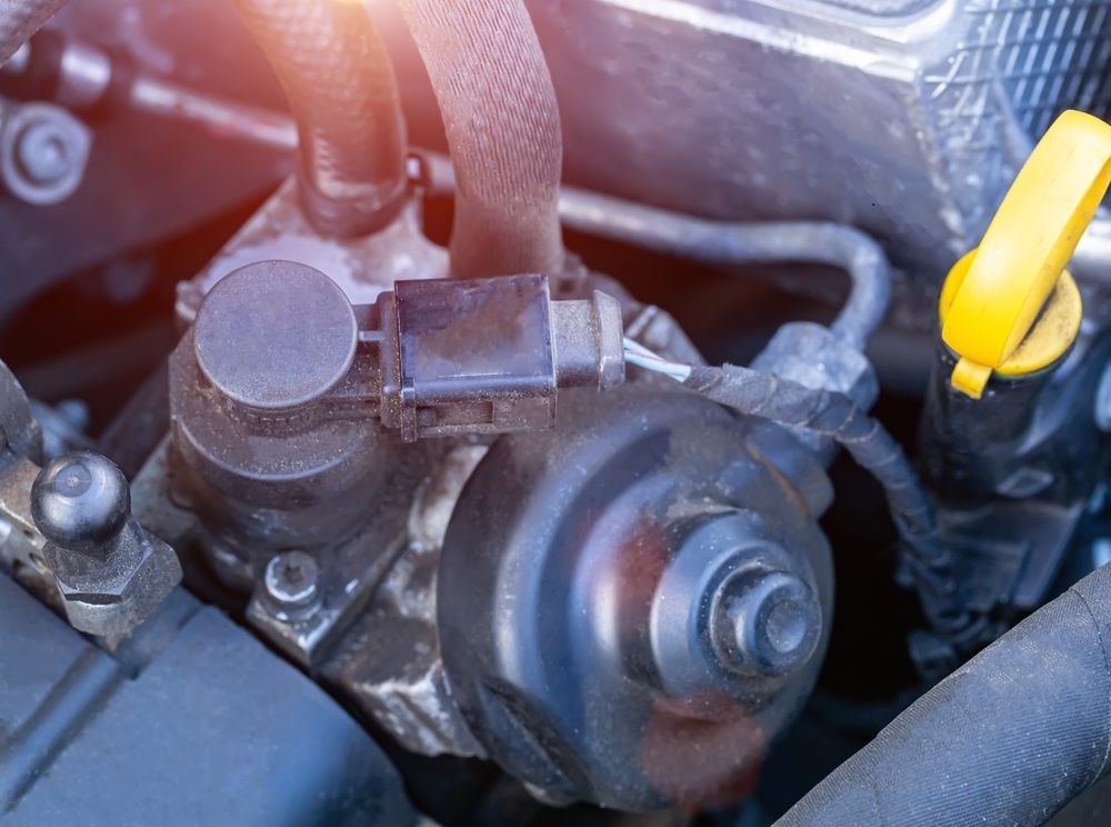 A close up of a EGR Valve with a yellow oil cap.