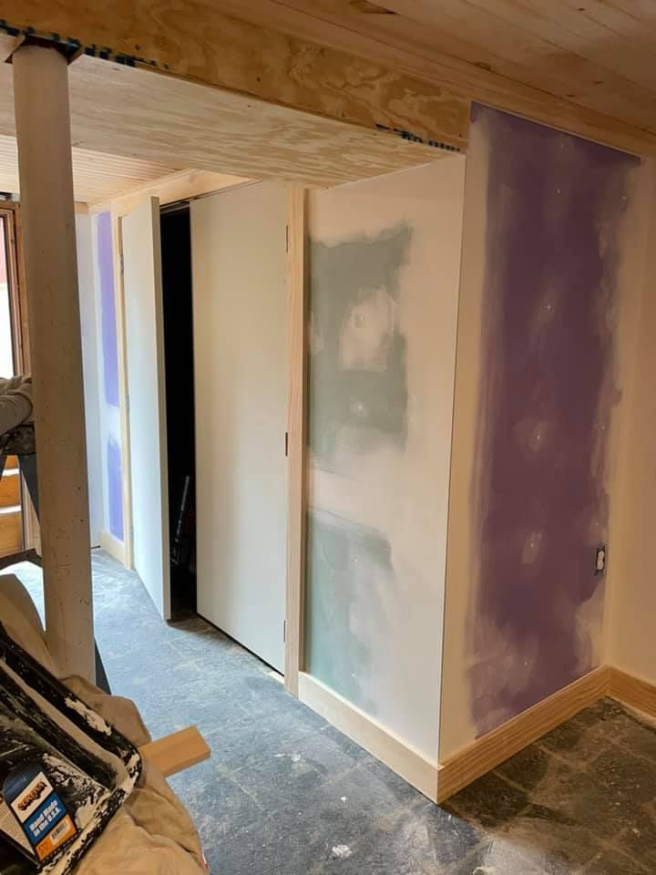 A room with purple walls and white walls is being remodeled.