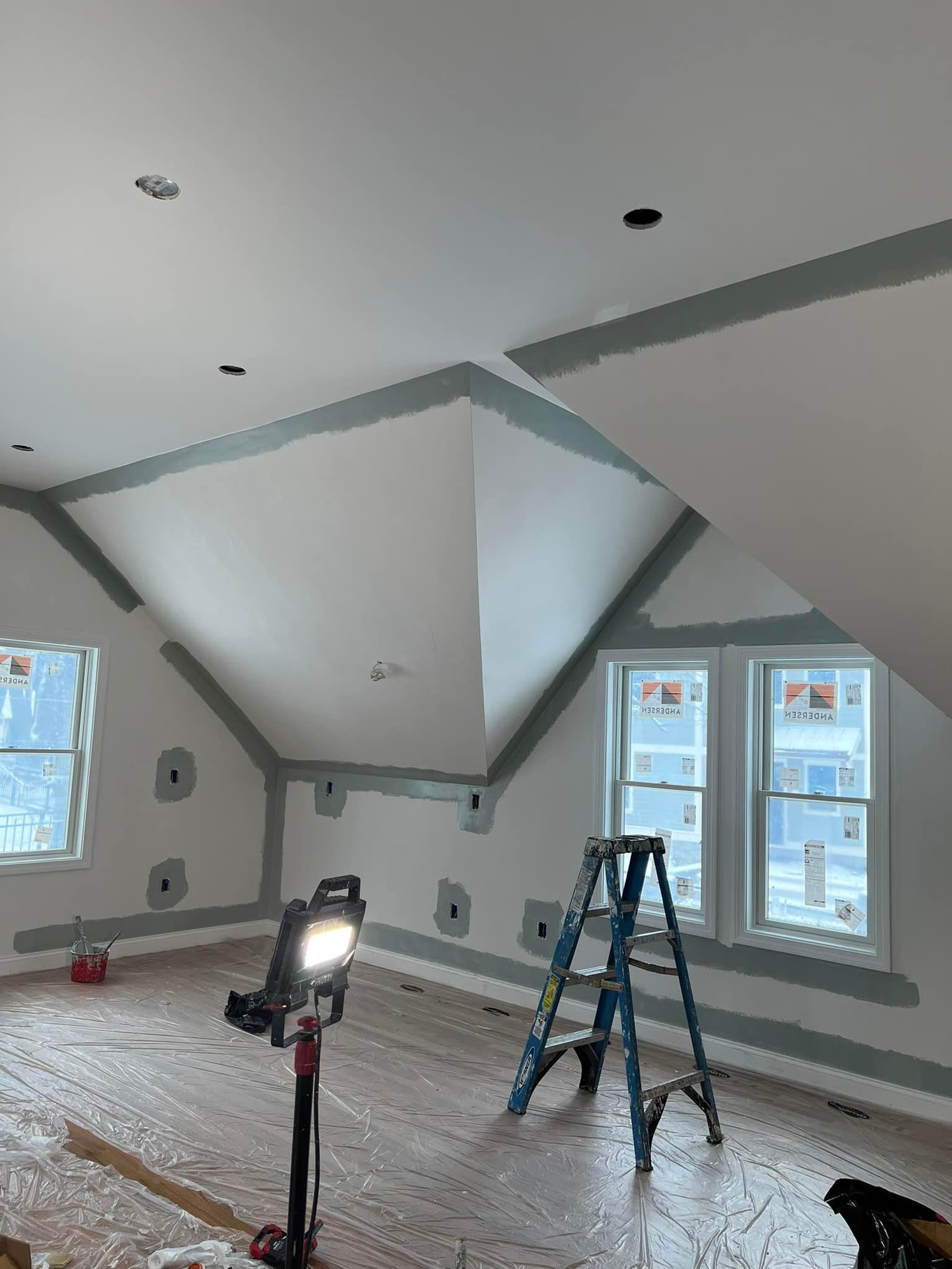 A room with a ladder and a light on the floor.