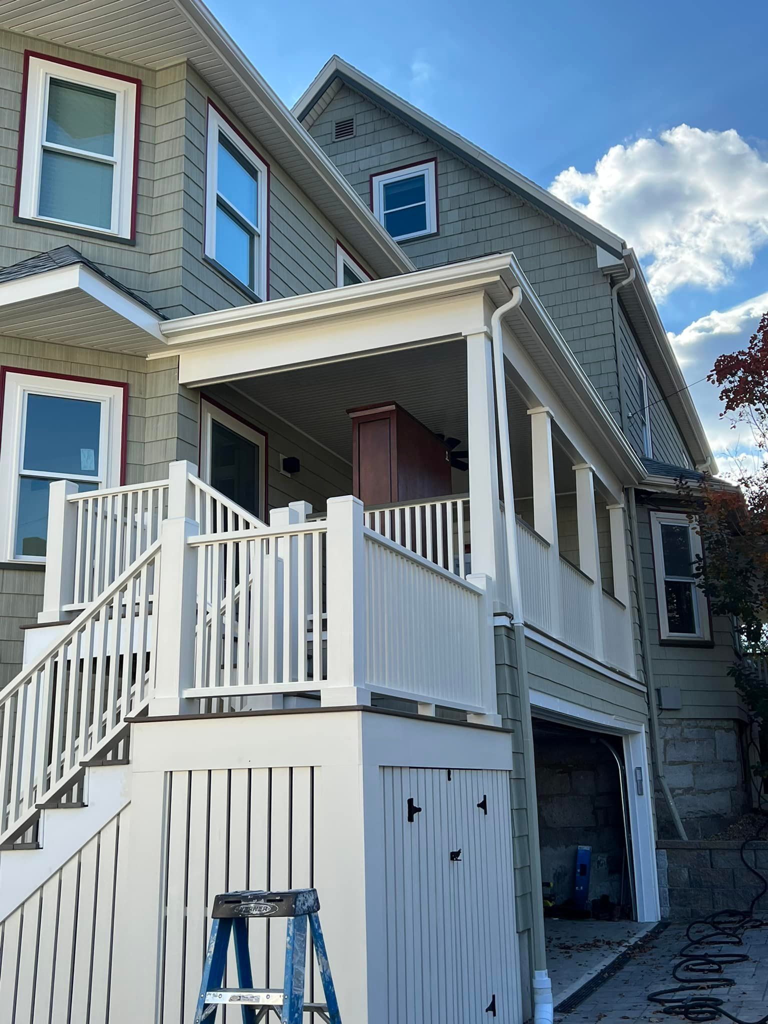 A large house with a white railing and stairs