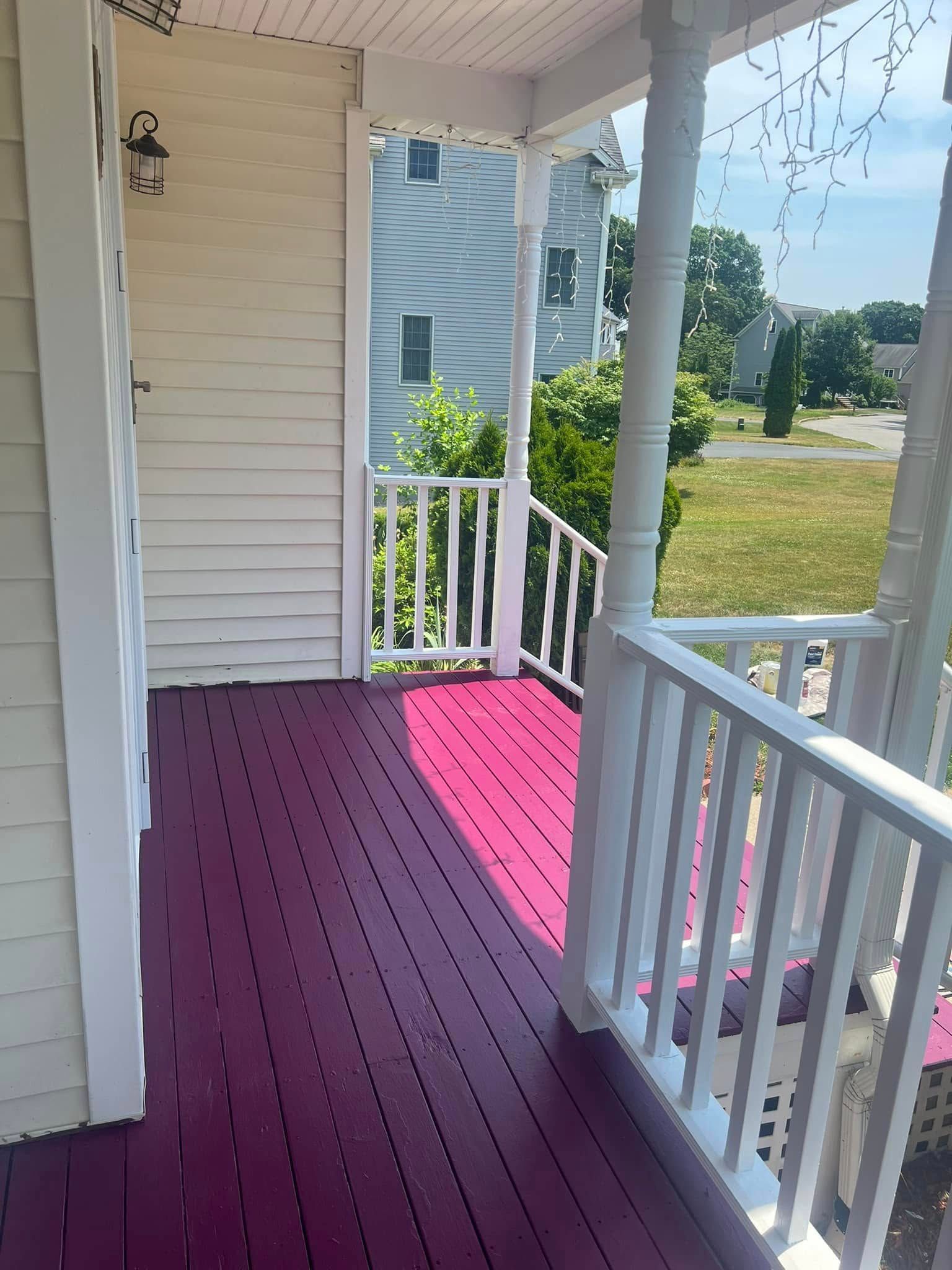 A white house with a pink porch and stairs