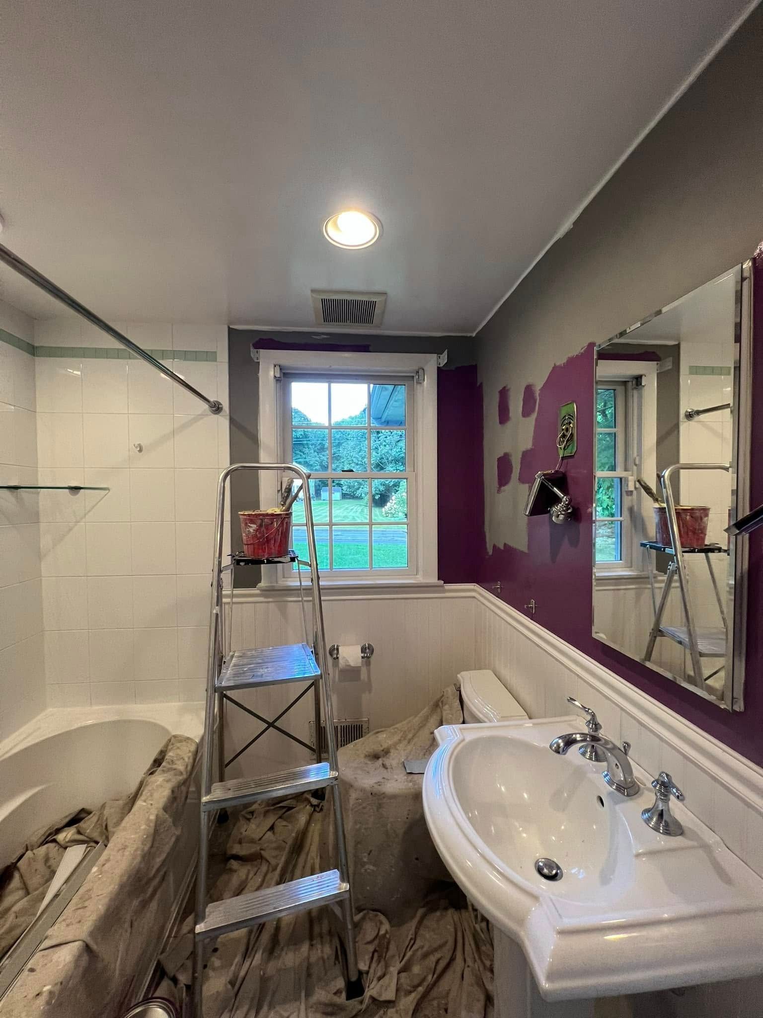 A bathroom with a sink , toilet , tub and mirror.