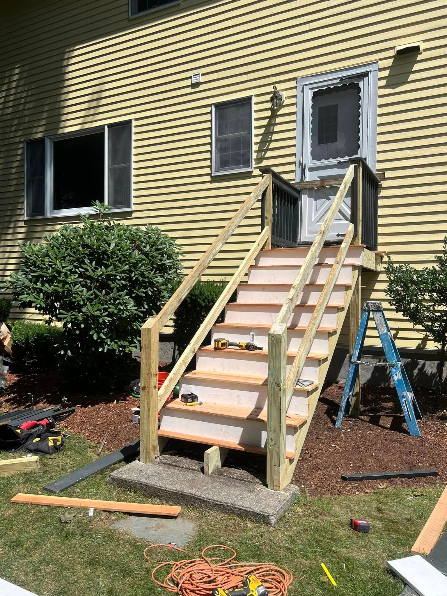 A wooden staircase is being built in front of a house.