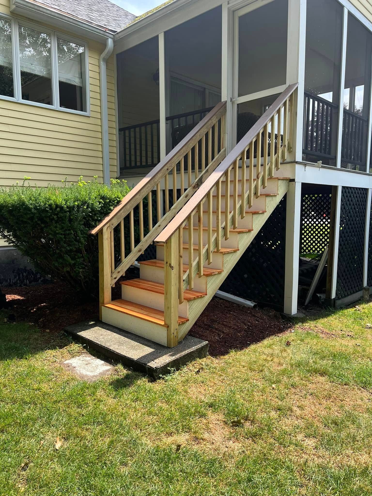 A house with a screened in porch and stairs leading up to it.