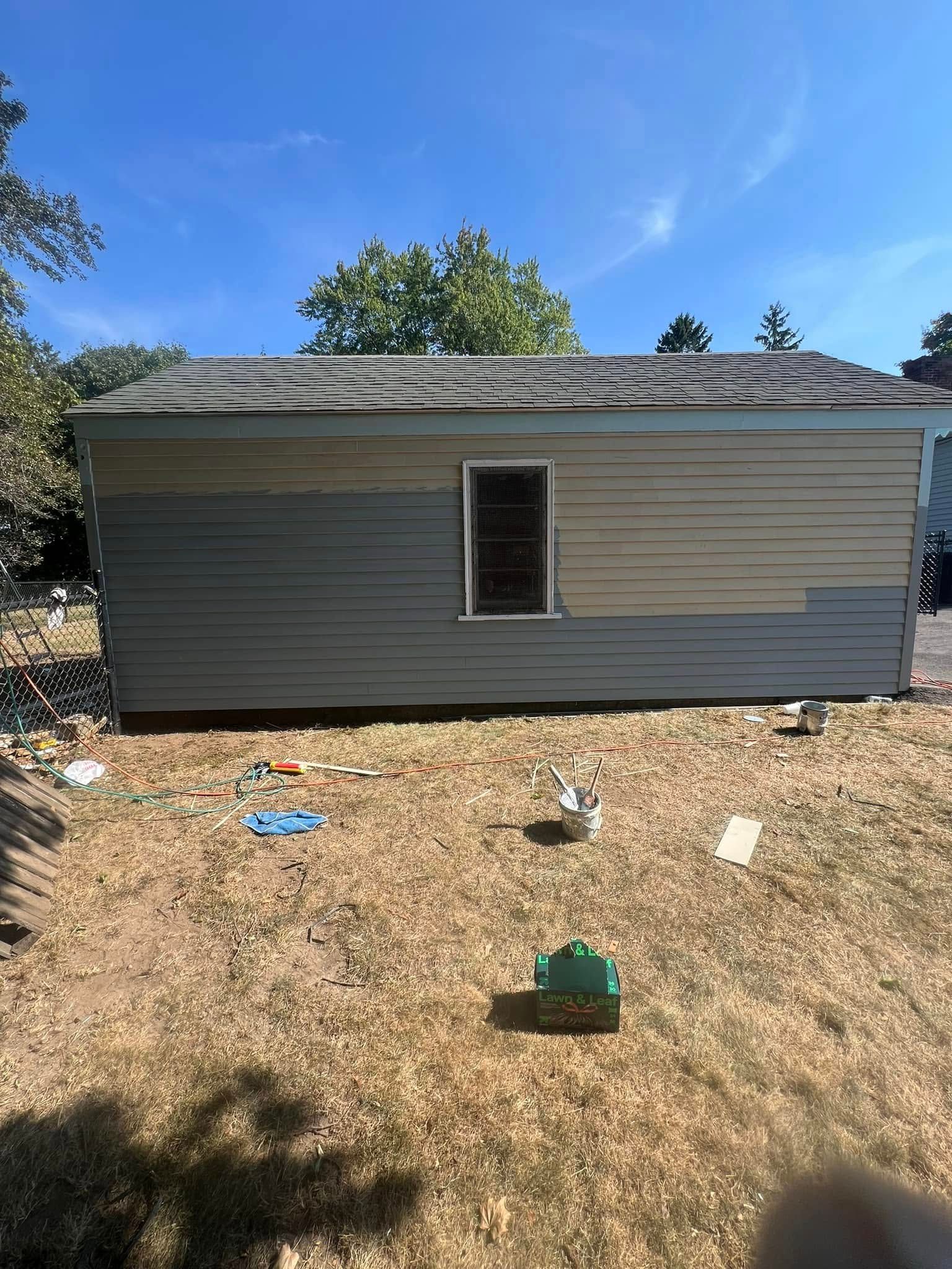 A small house is sitting in the middle of a dirt field.
