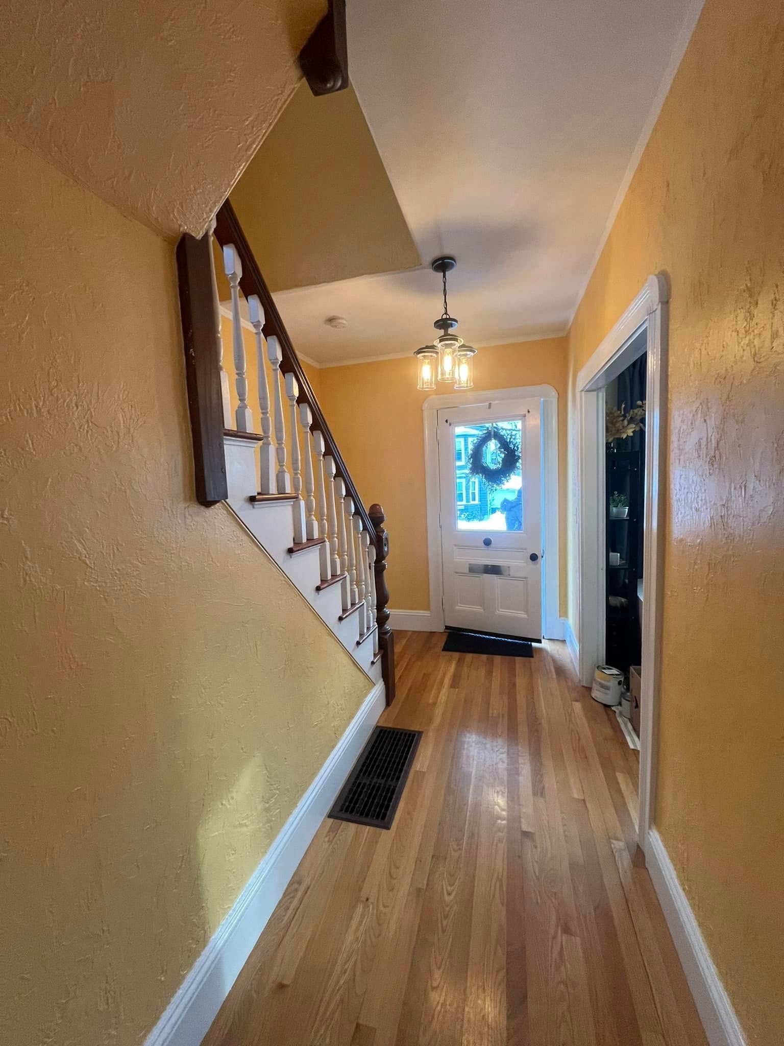 A hallway with stairs leading up to the second floor of a house.