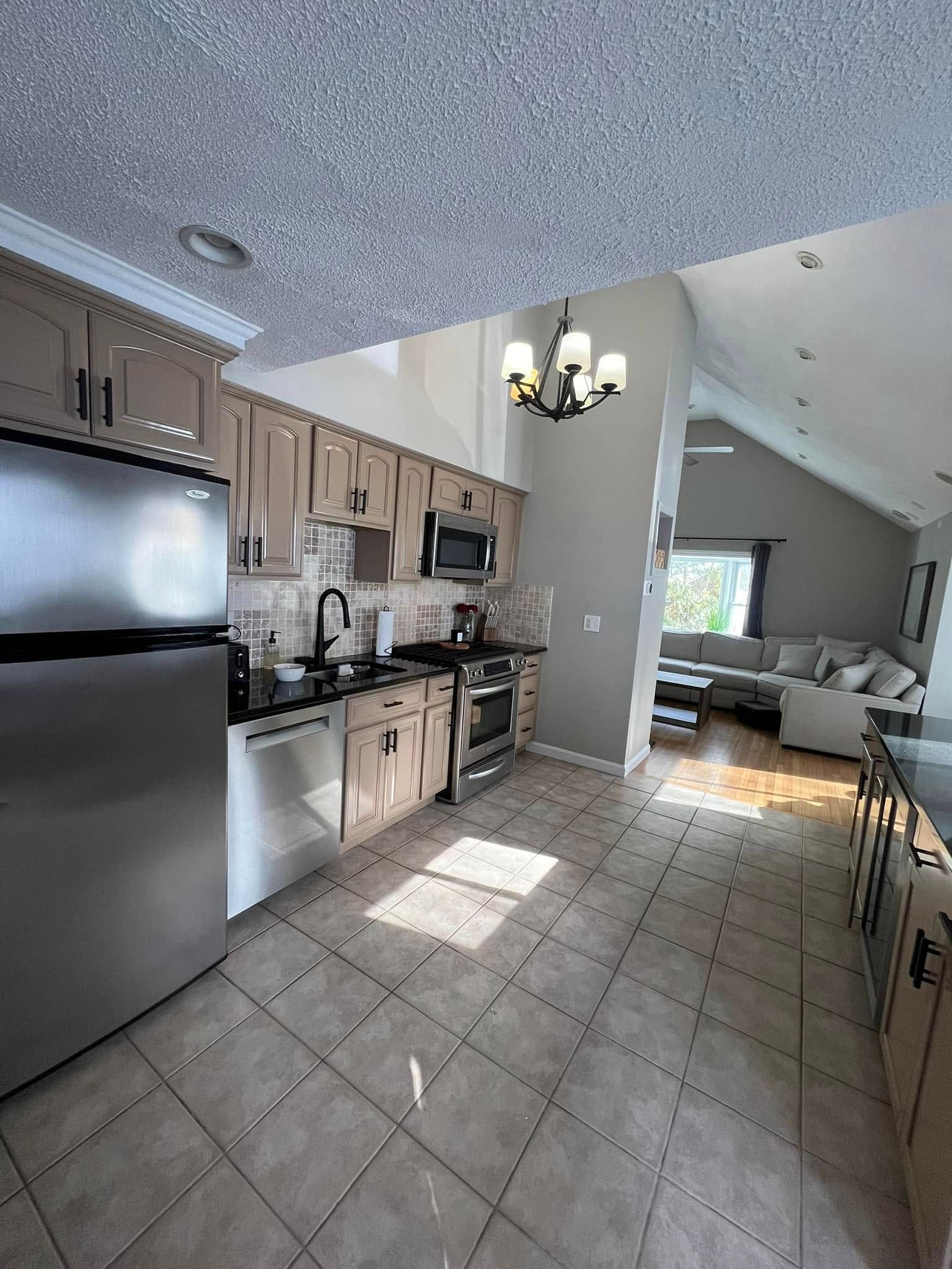 A kitchen with stainless steel appliances and a refrigerator.