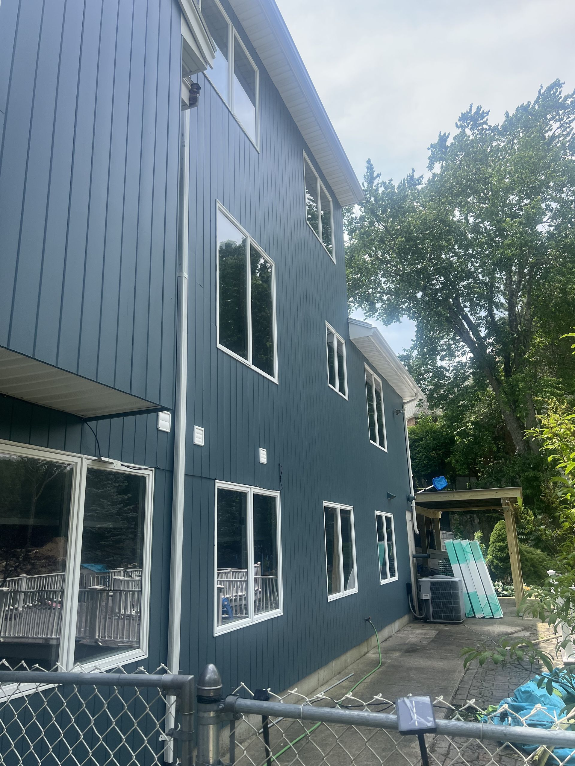 A blue house with a chain link fence in front of it.
