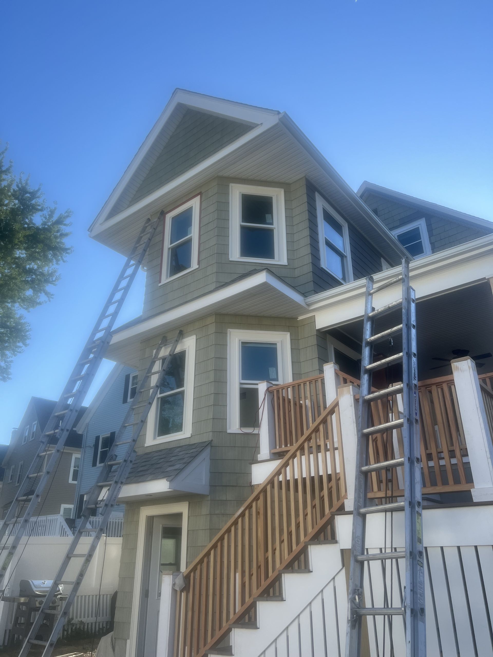 A house with stairs and a ladder in front of it