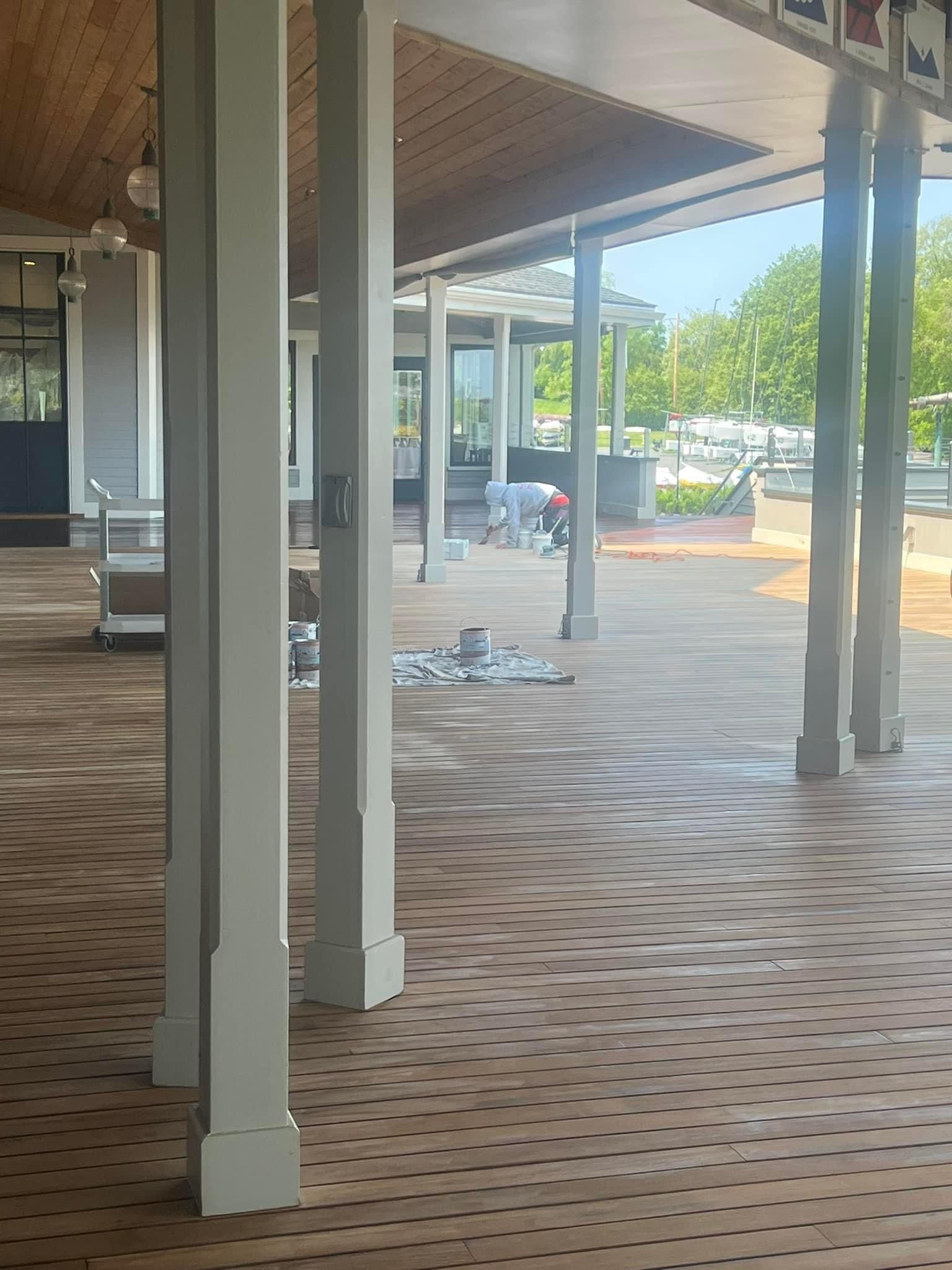 A man is working on the floor of a building under a canopy.