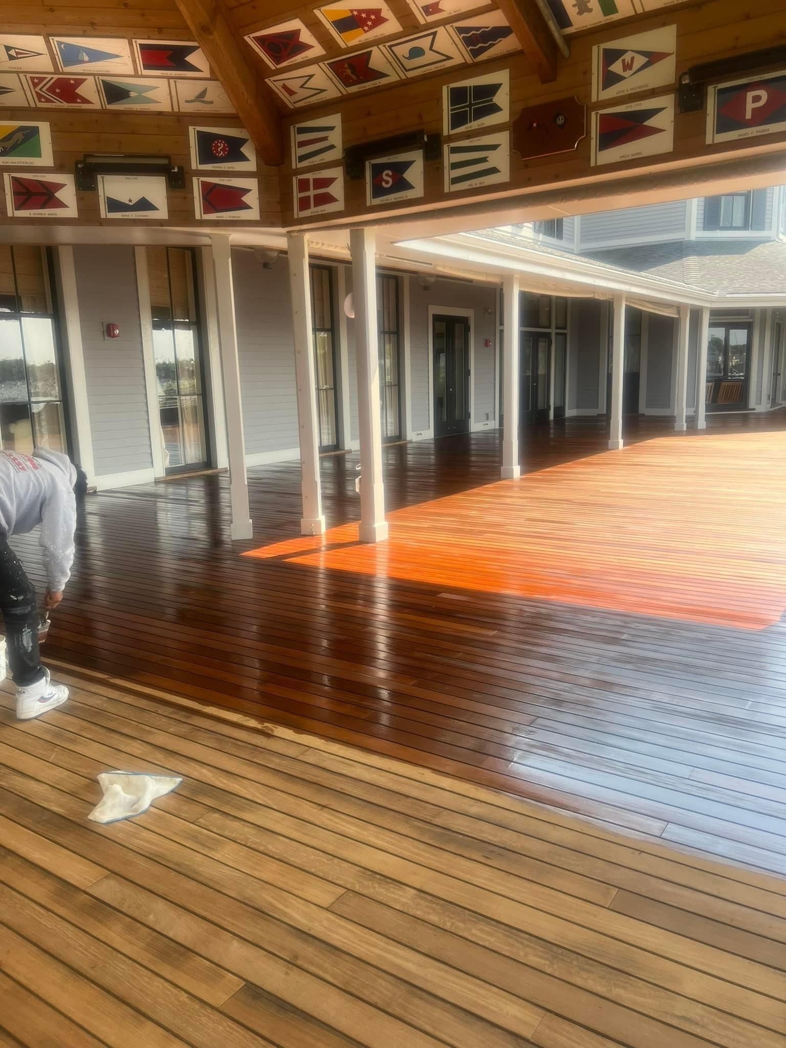 A person is standing on a wooden deck with flags on the ceiling.
