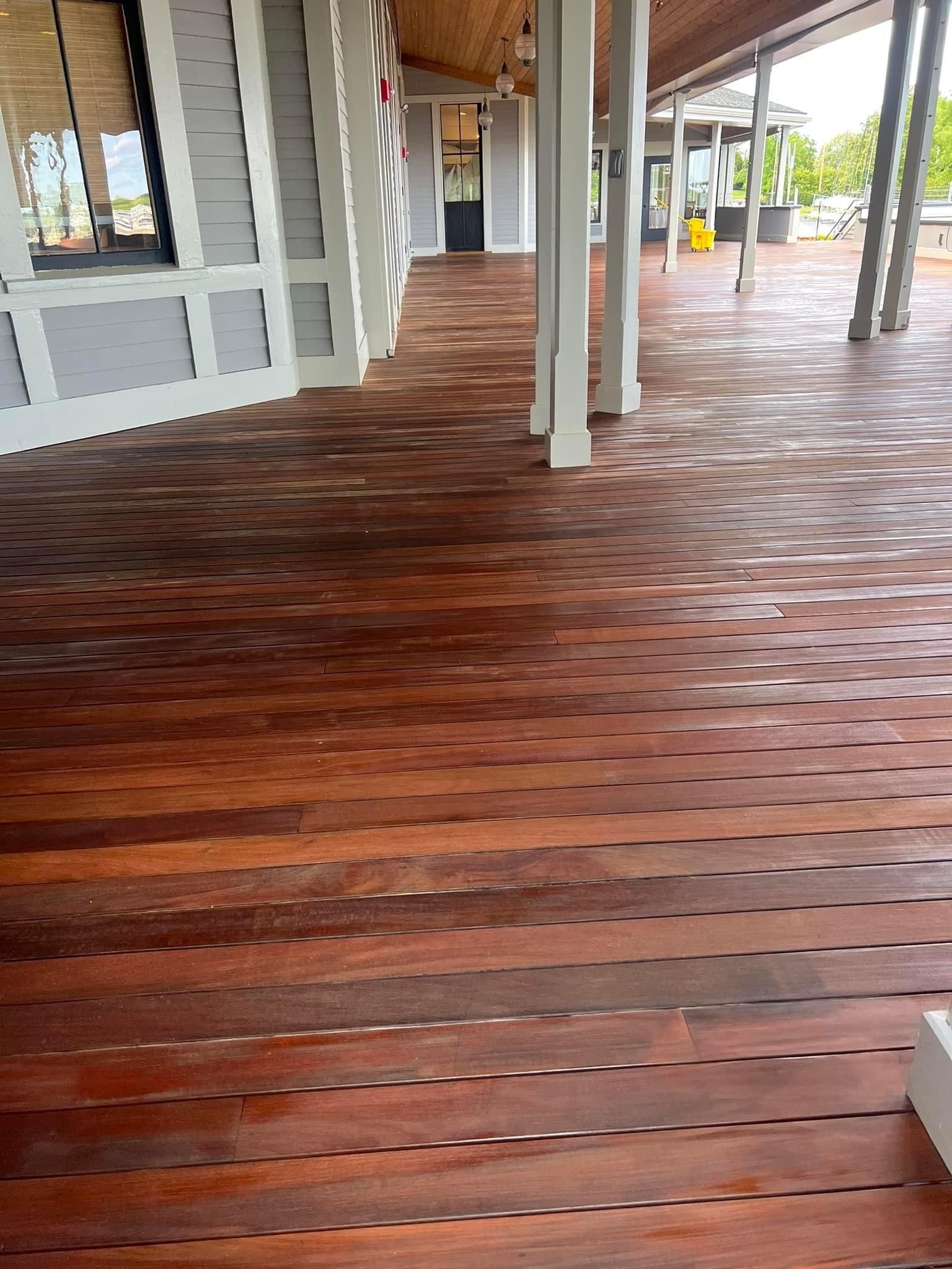 A large wooden deck with a white building in the background