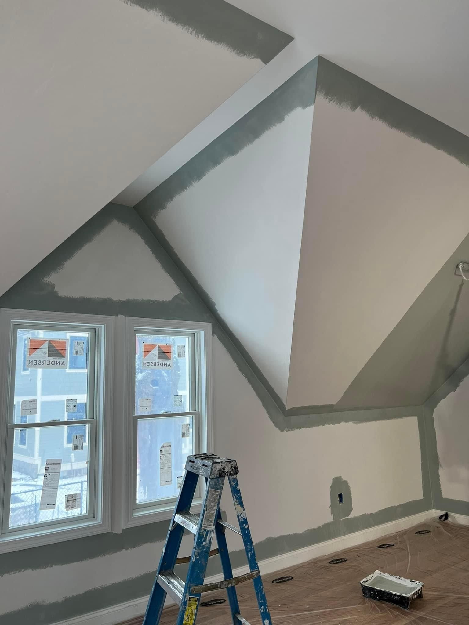 A ladder is sitting in a room that is being painted.