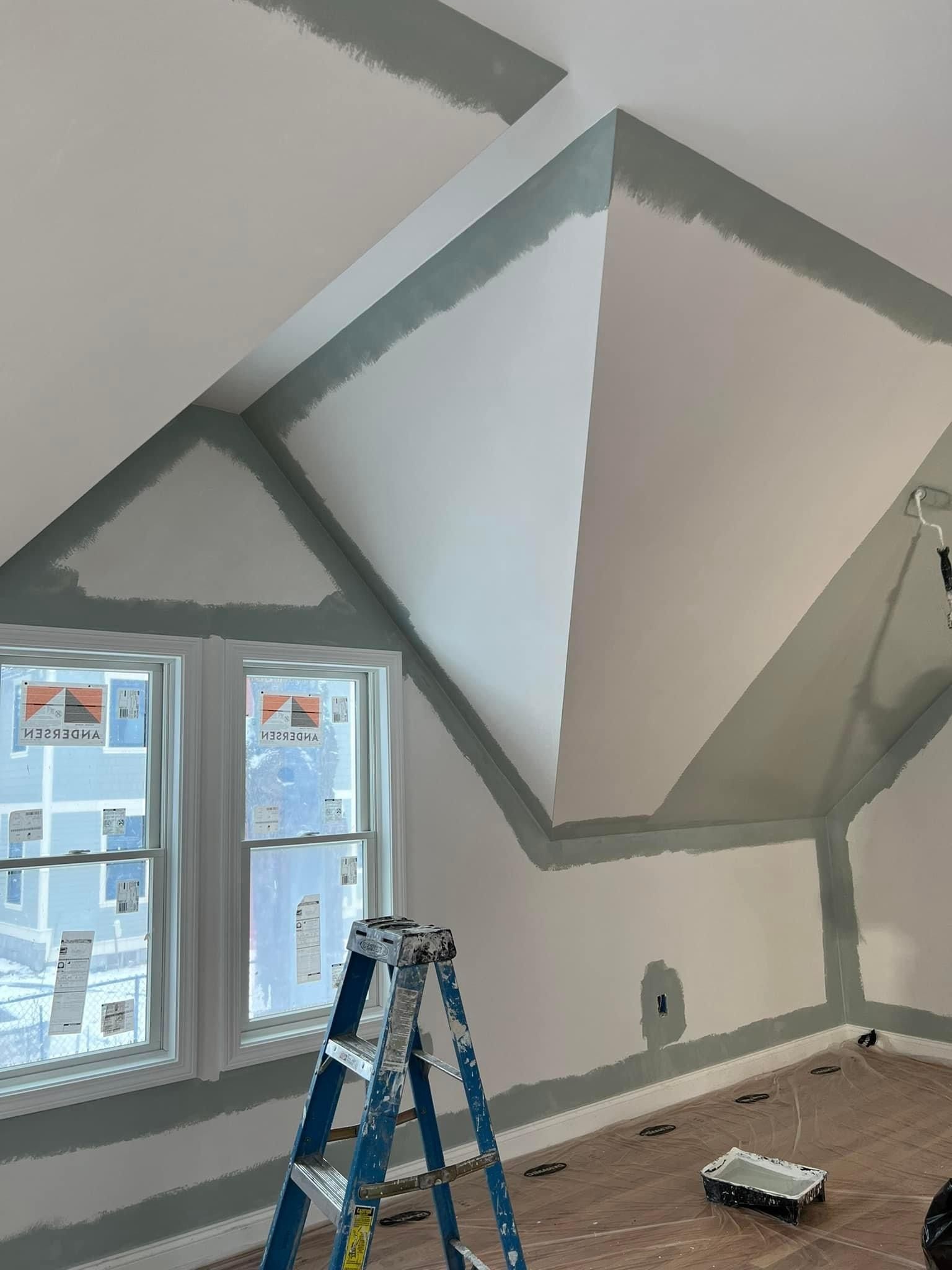 A ladder is sitting in a room that is being painted