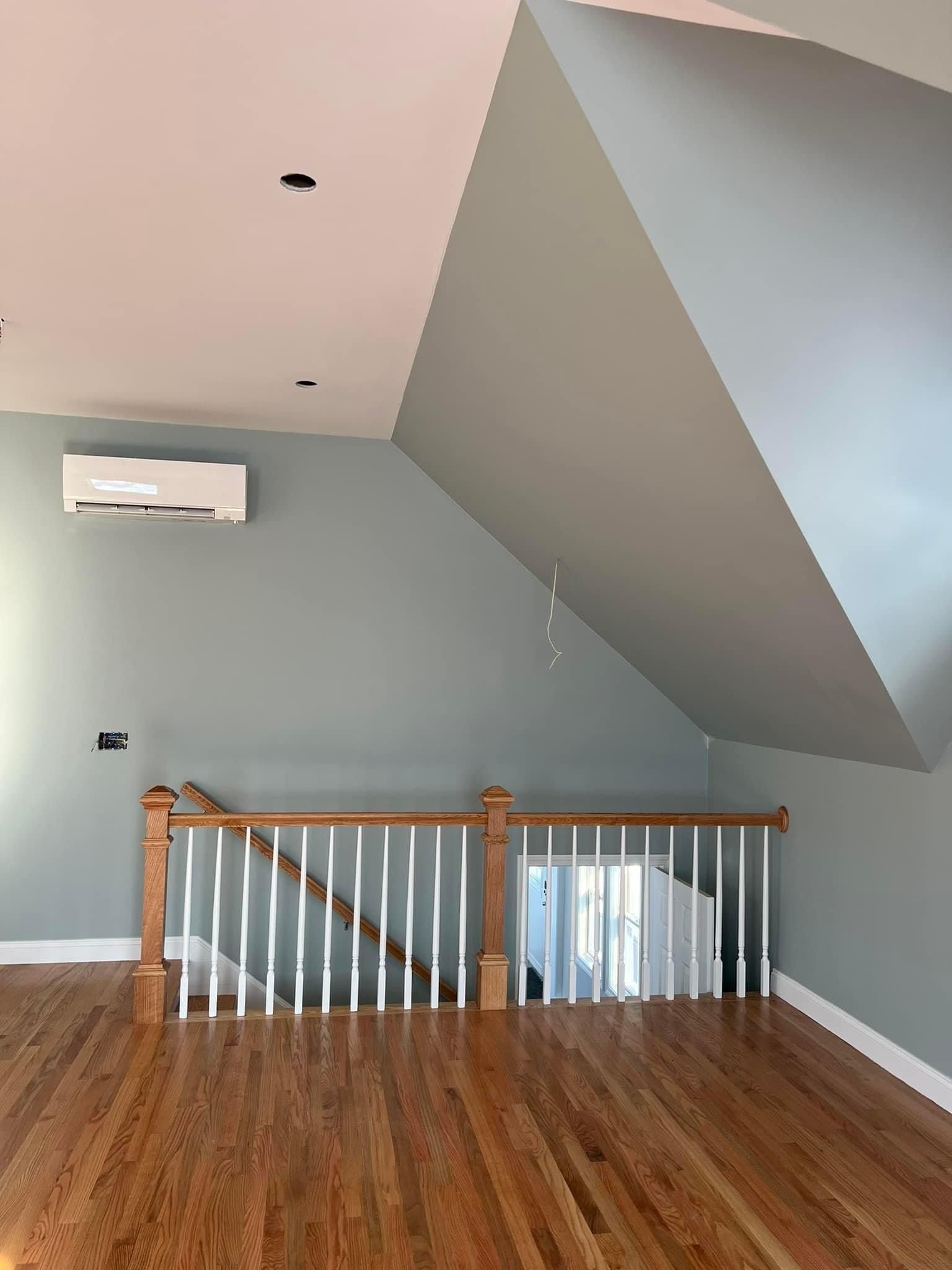 An empty room with hardwood floors and a staircase