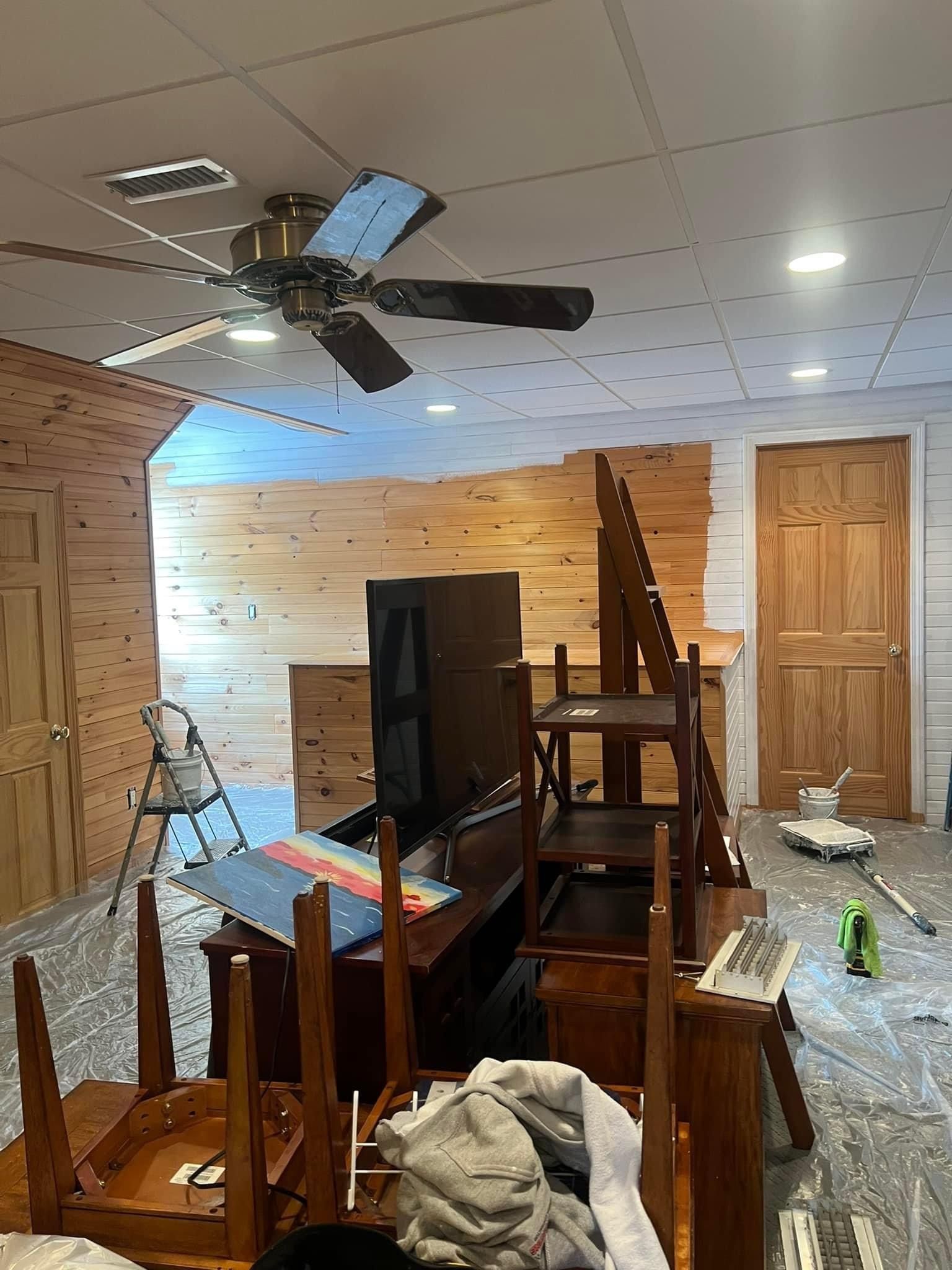 A ceiling fan is hanging from the ceiling of a room with wood paneling.