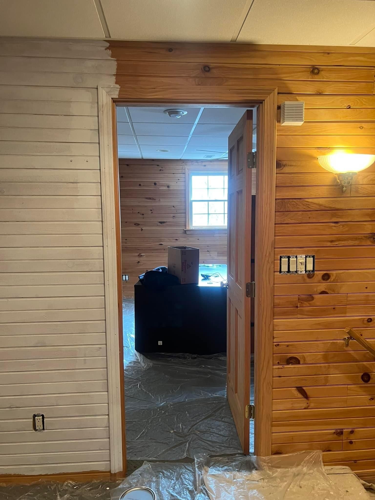 A doorway leading into a room with wood paneling on the walls.