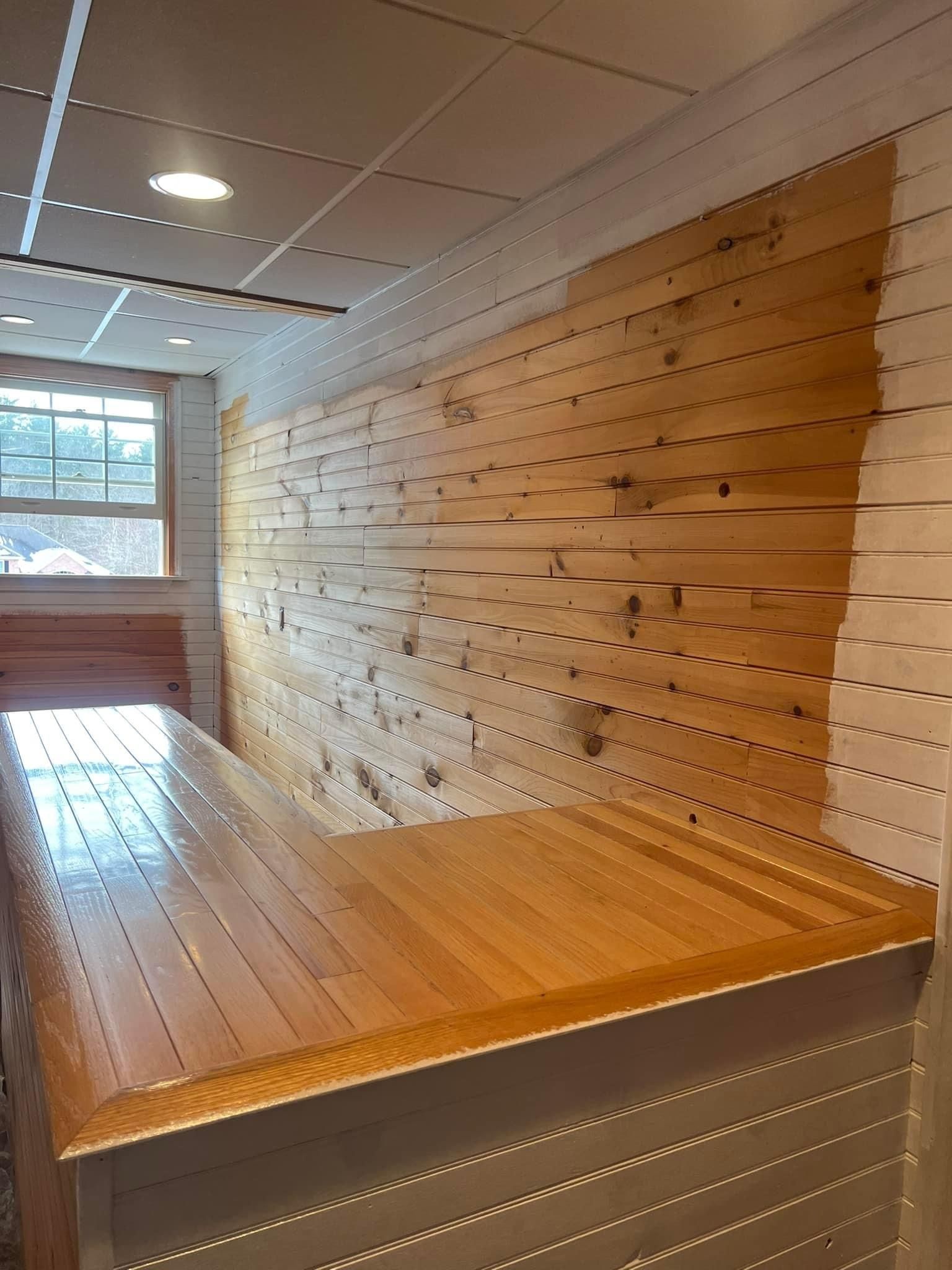 A wooden table is sitting in front of a wooden wall.