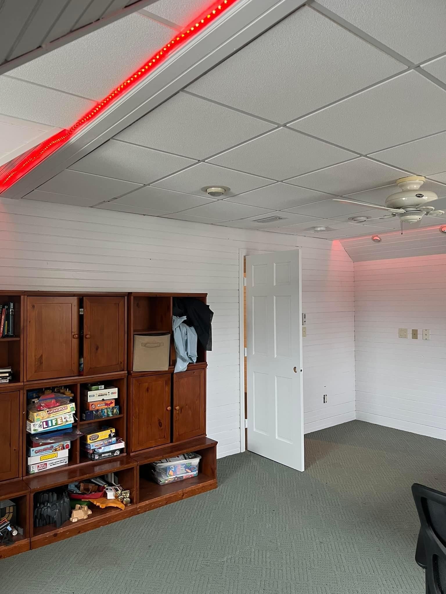A room with a lot of shelves and a ceiling fan