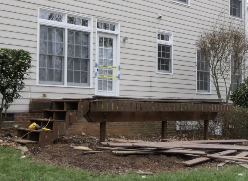 A house with a broken deck in front of it