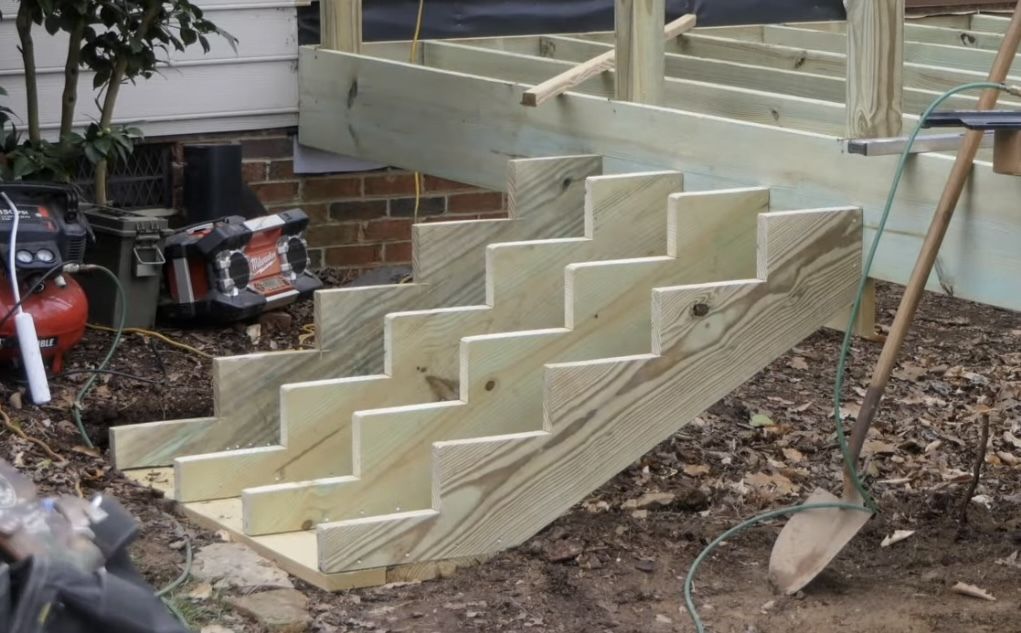 A wooden staircase is being built next to a shovel