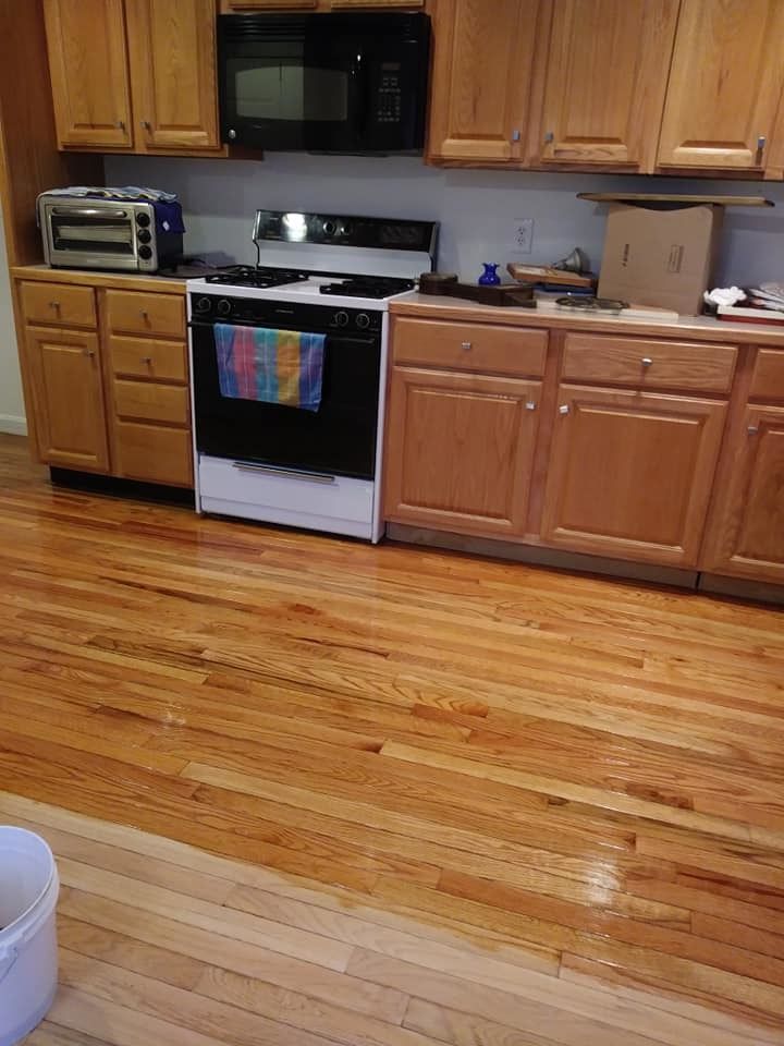 A kitchen with wooden cabinets and hardwood floors