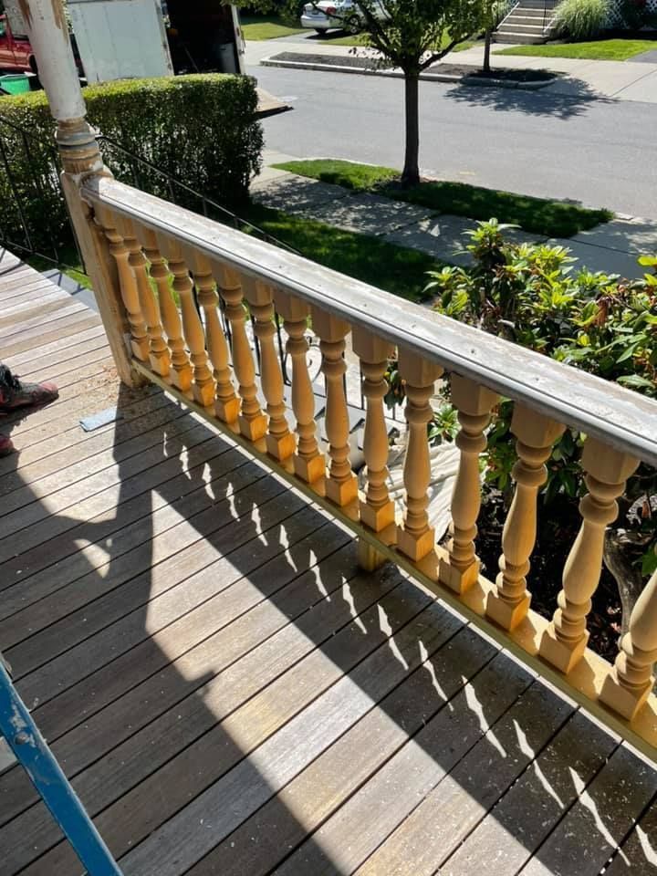 A person is standing on a wooden deck with a wooden railing.