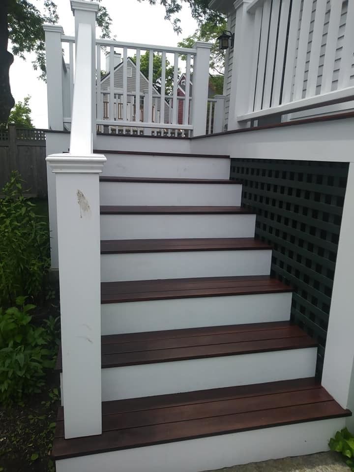 A set of wooden stairs with a white railing