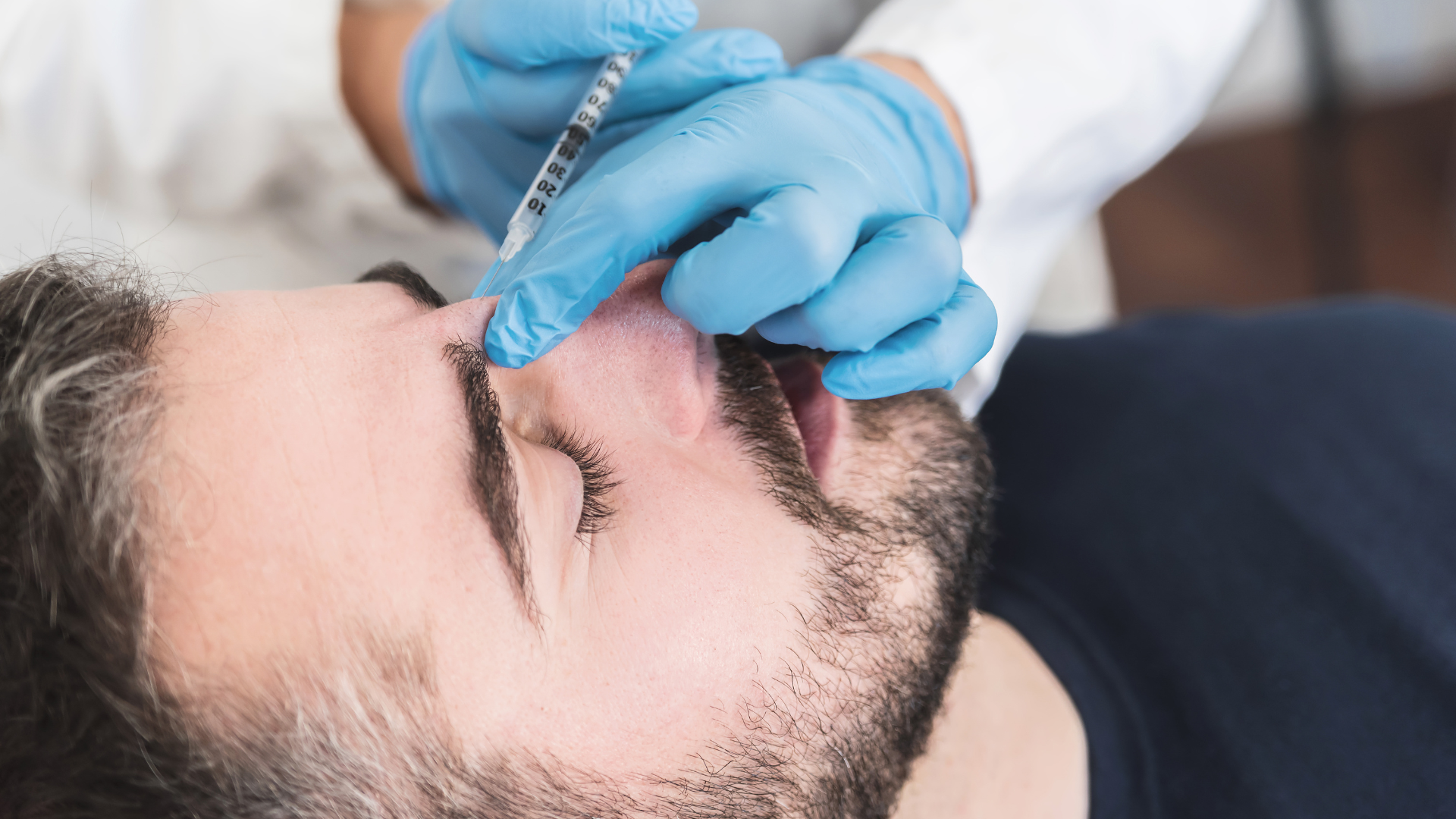 Woman receiving a facial injection, light skin, white background.