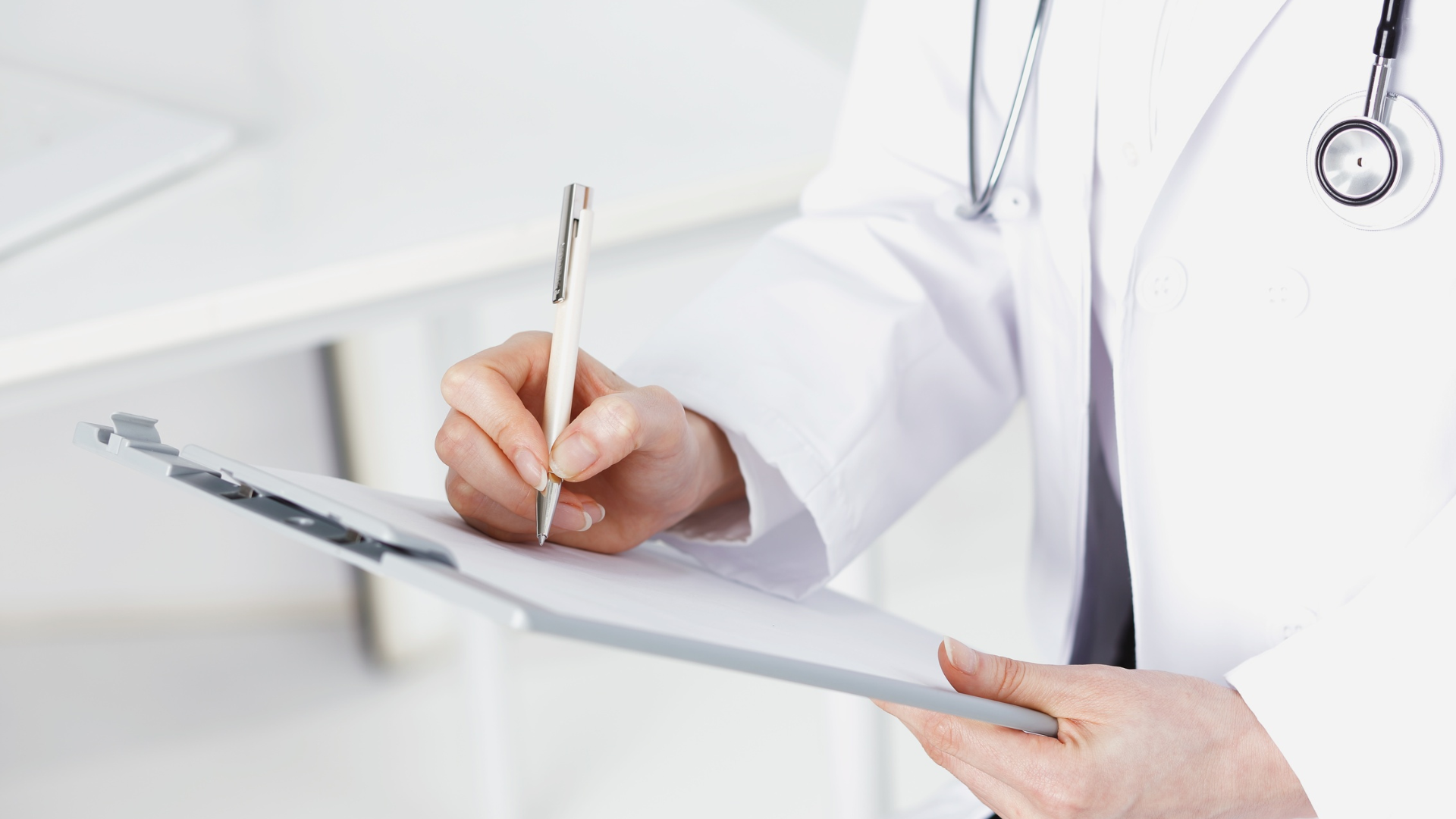 Woman with eyes closed has face examined by person in gloves in a white room.