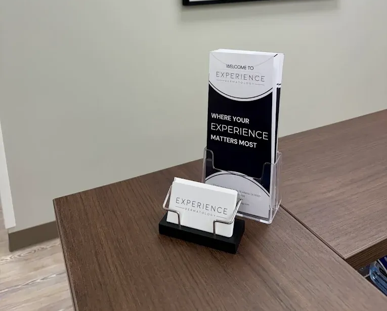 Brochure stand on a wooden table beside a sign reading “Your Experience Matters”