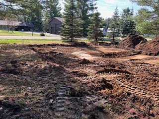 A large pile of dirt is sitting in the middle of a dirt field.